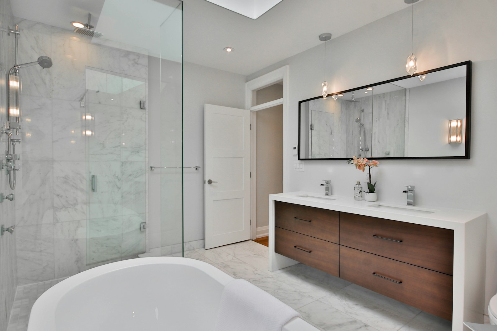 a bathroom with a large white bathtub next to a walk in shower